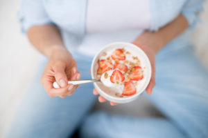 Unrecognizable woman eating a healthy bowl of cereals for breakfast